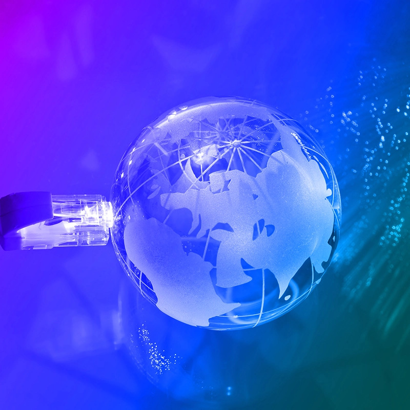 Una clavija enchufada a una bola del mundo. Referencia a telecomunicaciones a nivel mundial.